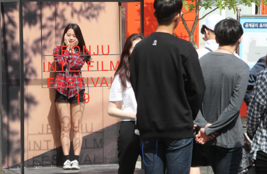 11일 오후 제19회 전주국제영화제가 열리고 있는 전북 전주시 완산구 '전주 영화의 거리'에서 관광객들이 영화제 포토존에서 사진촬영을 하고 있다.